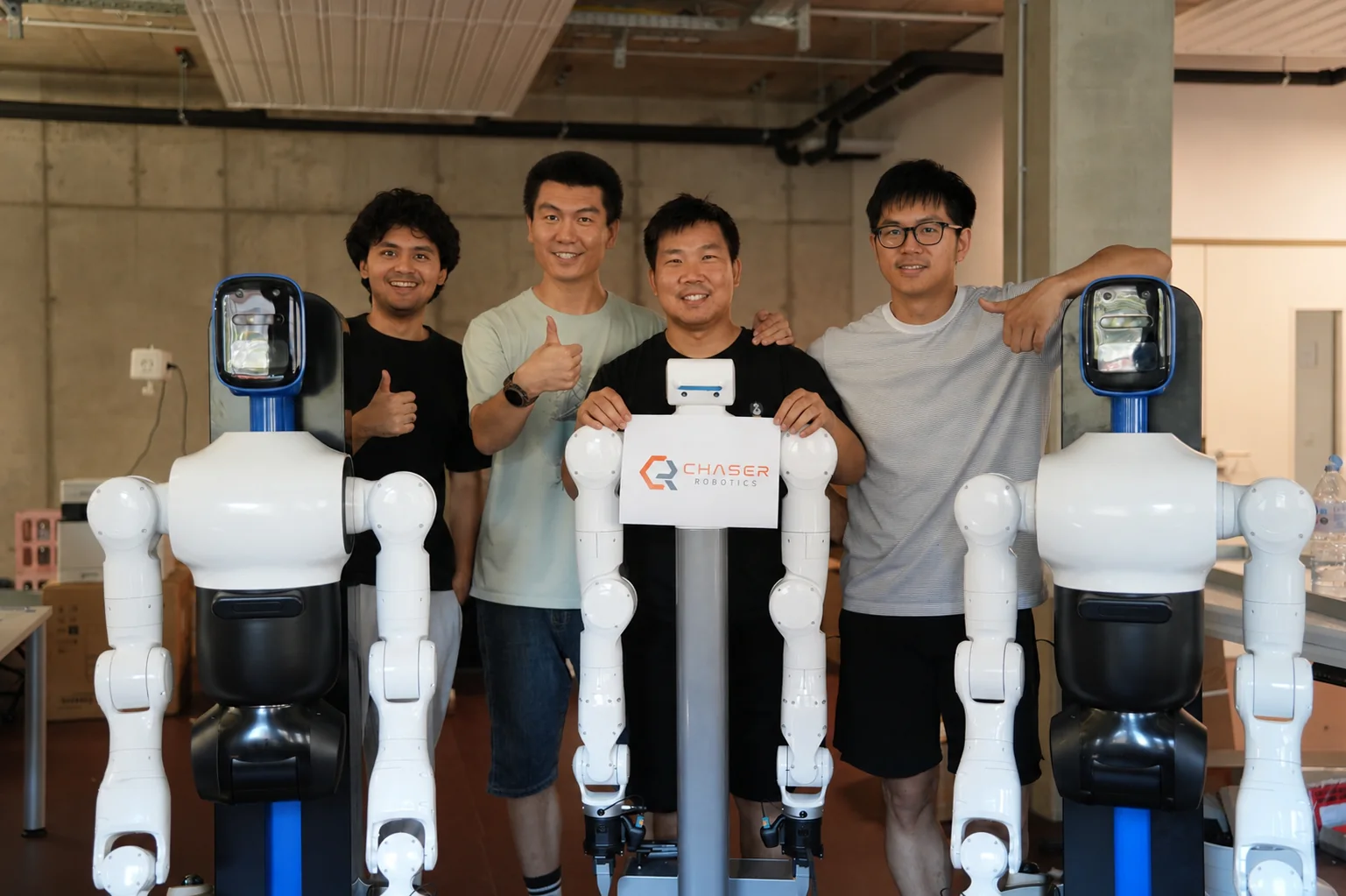 The Chaser team with three of its mobile dual-arm robots in the Karlsruhe lab